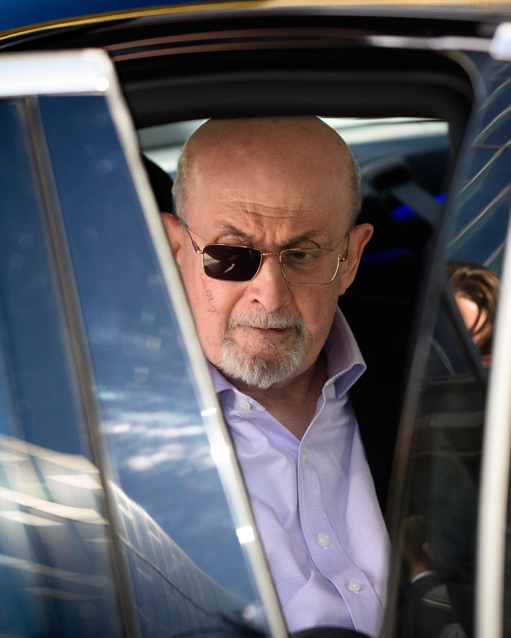 Der Schriftsteller Salman Rushdie in einer gepanzerten Limousine. Rushdie, der wegen eines Mordaufrufs gegen ihn aus dem Iran bereits seit den 1990er Jahren unter Polizeischutz steht, setzt sich in seinem neuen Buch „Knife“ mit einem Messer-Angriff auf ihn im Jahr 2022 in den USA auseinander. Damals war er von einem Mann mit einem Messer lebensgefährlich verletzt worden. 