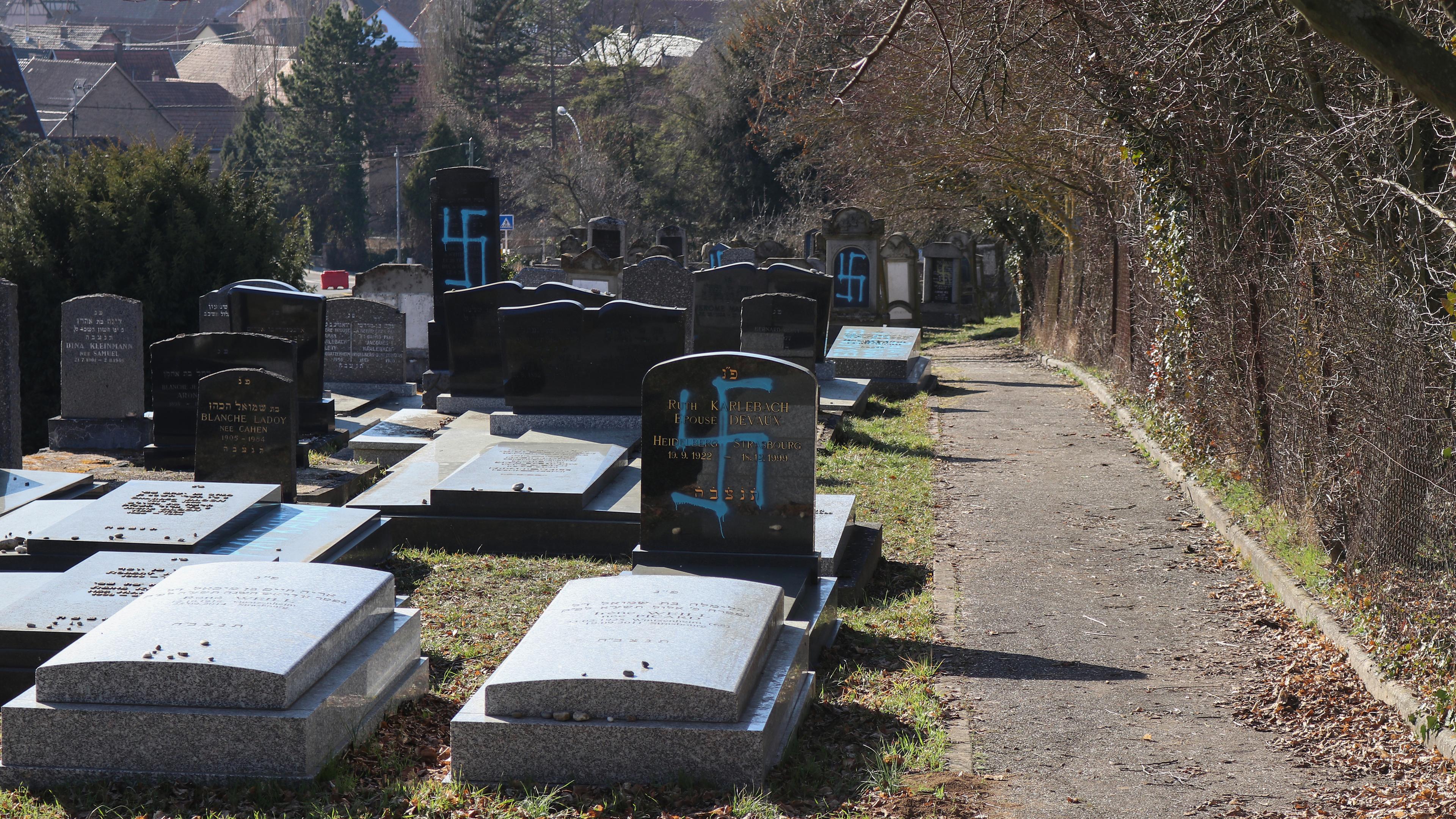 Auf zahlreichen Grabsteinen des jüdischen Friedhofes von Quatzenheim sind aufgesprühte Hakenkreuze zu sehen.