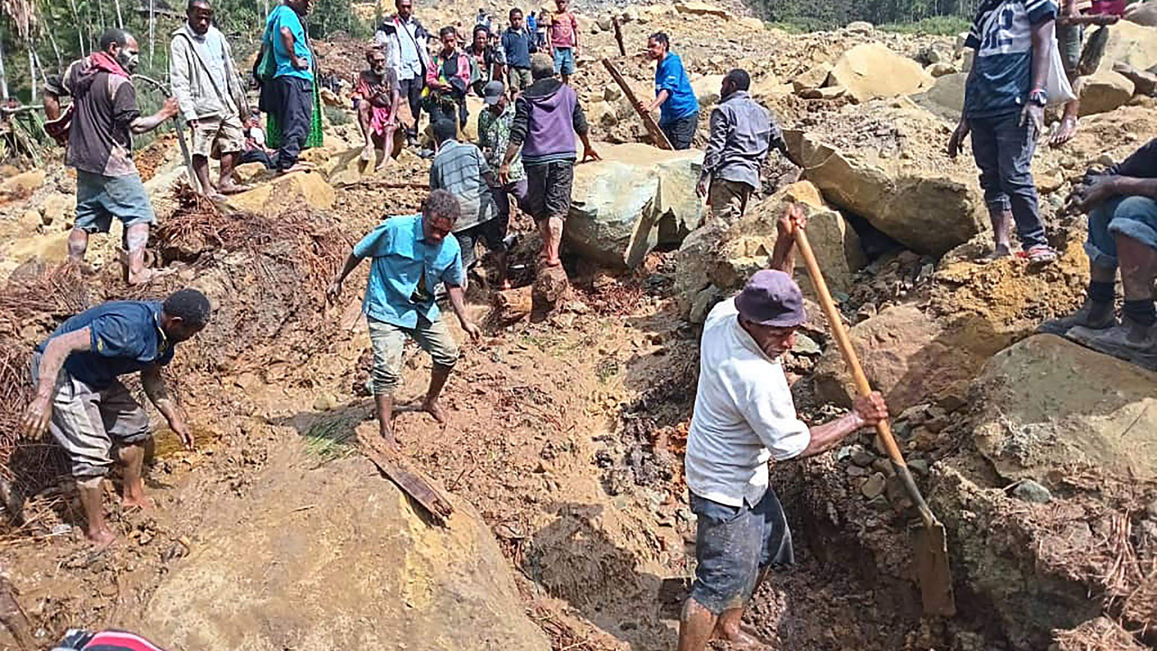 This handout photo taken and received on May 26, 2024 from the International Organization for Migration shows people digging at the site of a landslide at Yambali Village in the region of Maip Mulitaka, in Papua New Guinea's Enga Province. More than 670 people are believed dead after a massive landslide in Papua New Guinea, a UN official told AFP on May 26 as aid workers and villagers braved perilous conditions in their desperate search for survivors. (Photo by Mohamud Omer / International Organization for Migration / AFP) / RESTRICTED TO EDITORIAL USE - MANDATORY CREDIT "AFP PHOTO / INTERNATIONAL ORGANIZATION FOR MIGRATION / MOHAMUD OMER - NO MARKETING NO ADVERTISING CAMPAIGNS - DISTRIBUTED AS A SERVICE TO CLIENTS - NO ARCHIVE