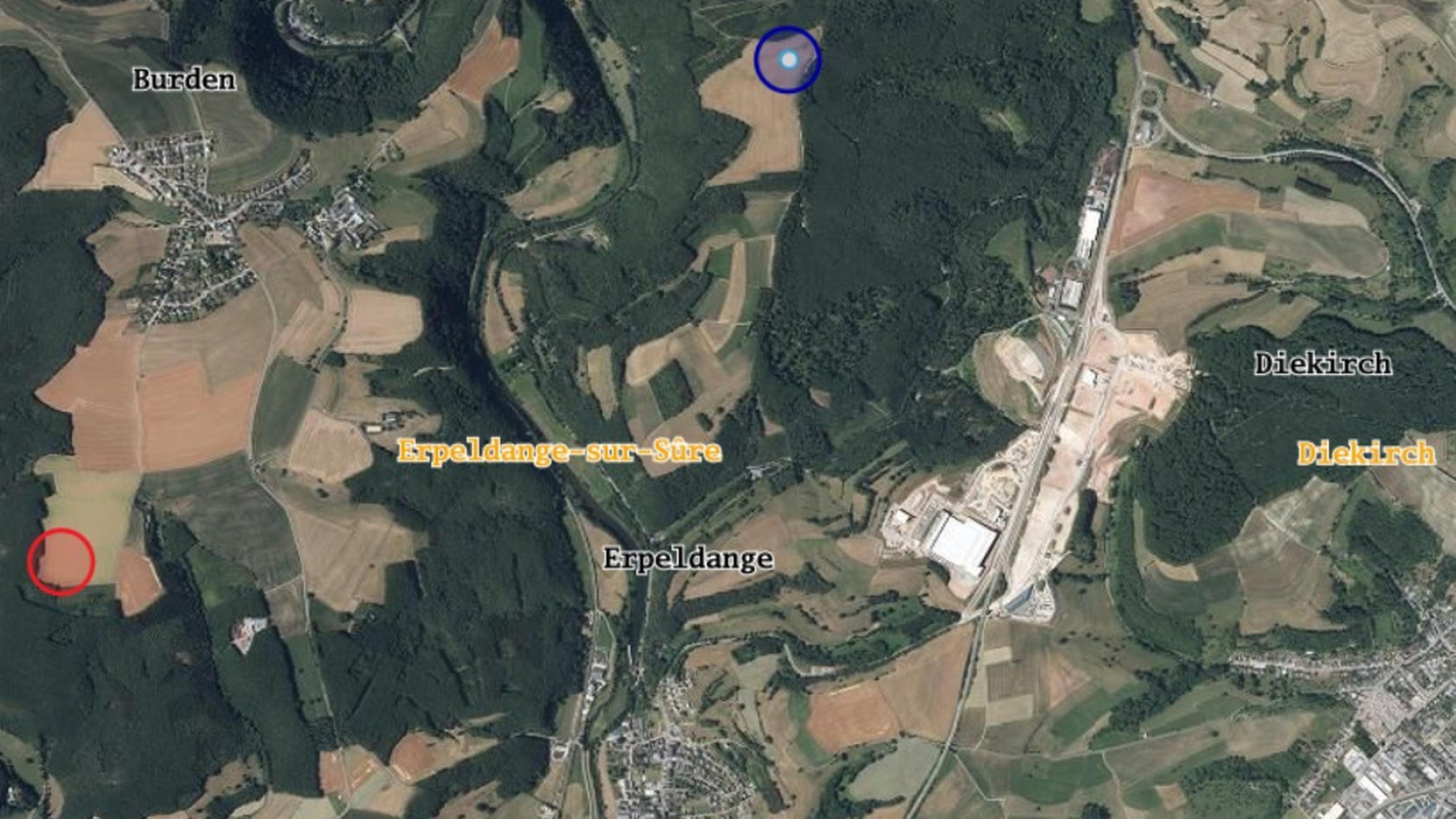 In Rot der geplante Standort für die Windkraftanlage unterhalb von Bürden. Jüngst hatte die Gemeinde Erpeldingen/Sauer nun aber einen Alternativstandort (blau) vorgeschlagen, der weiter von den nächsten Wohngebieten entfernt läge.