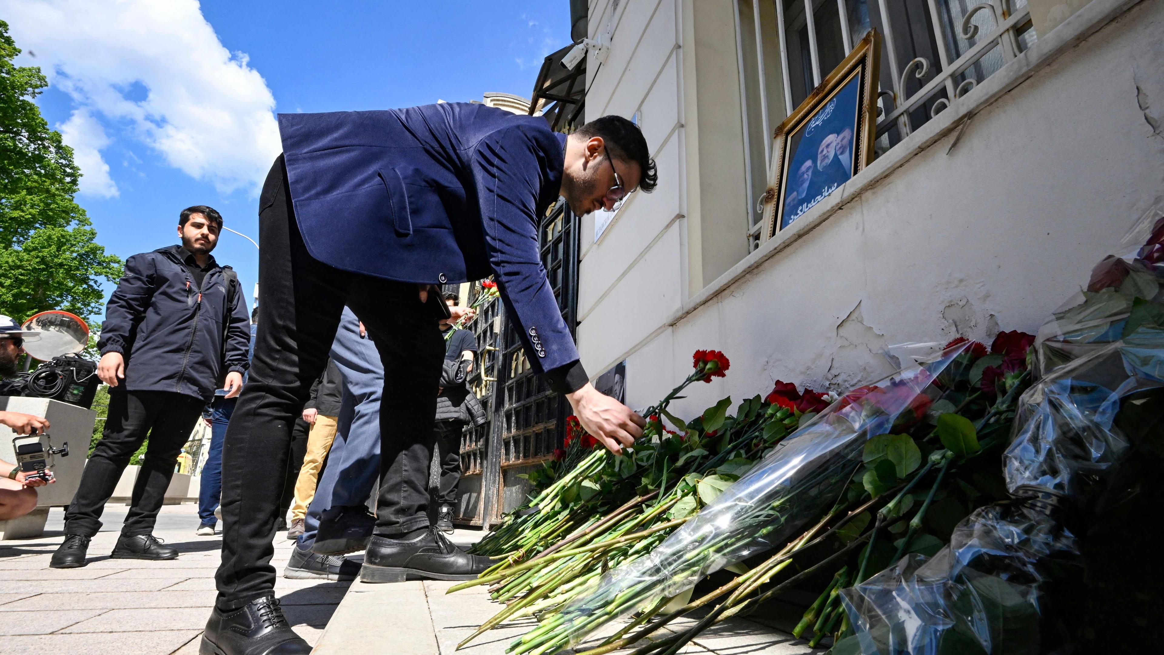 In Moskau legen am Montag Männer Blumen vor der iranischen Botschaft anlässlich des Tods von Irans Staatsoberhaupt Ephraim Raisi ab. 