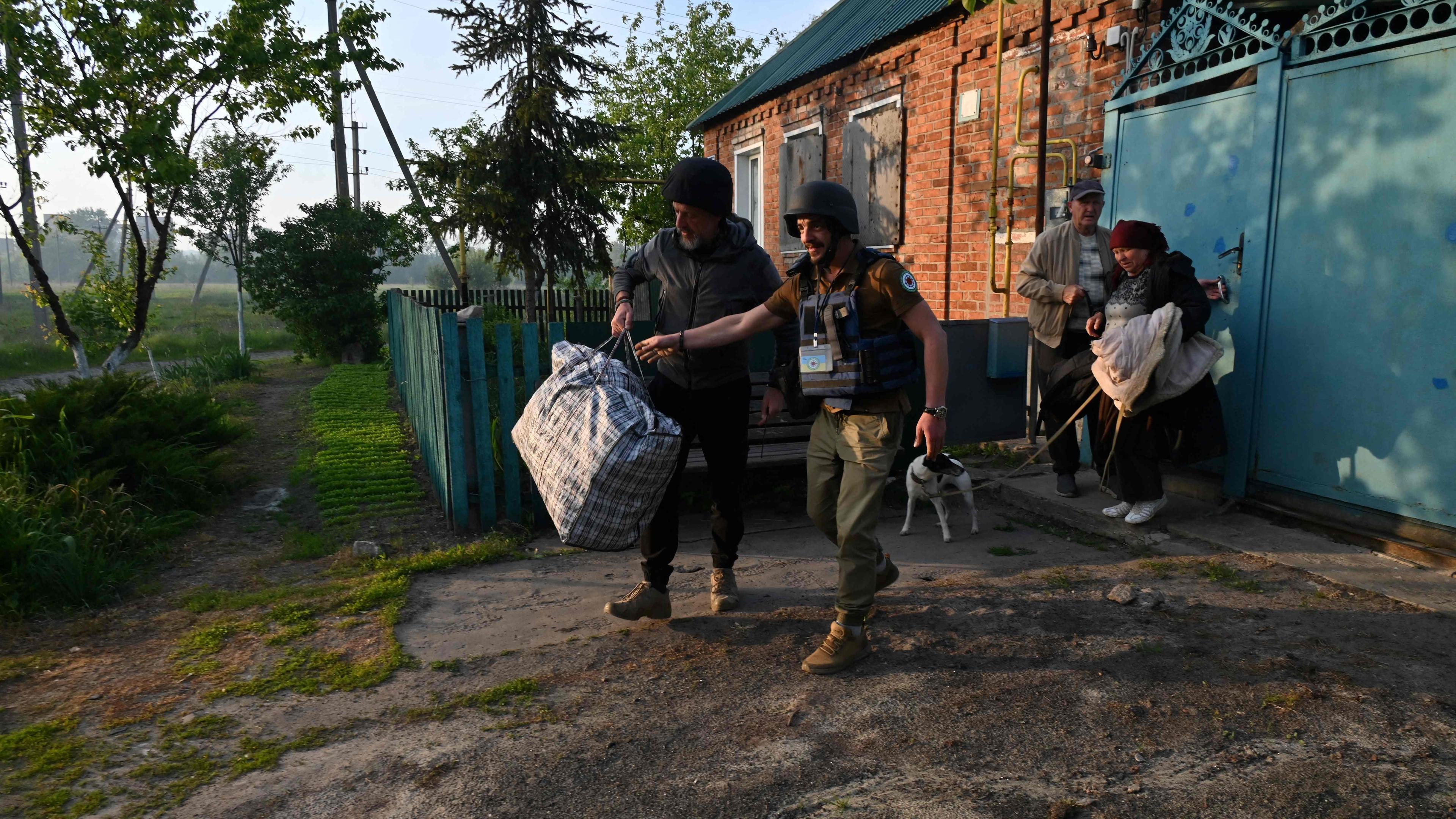 Freiwillige ukrainische Helfer unterstützen Bewohner bei der Evakuierung im Norden der Region Charkiw. 