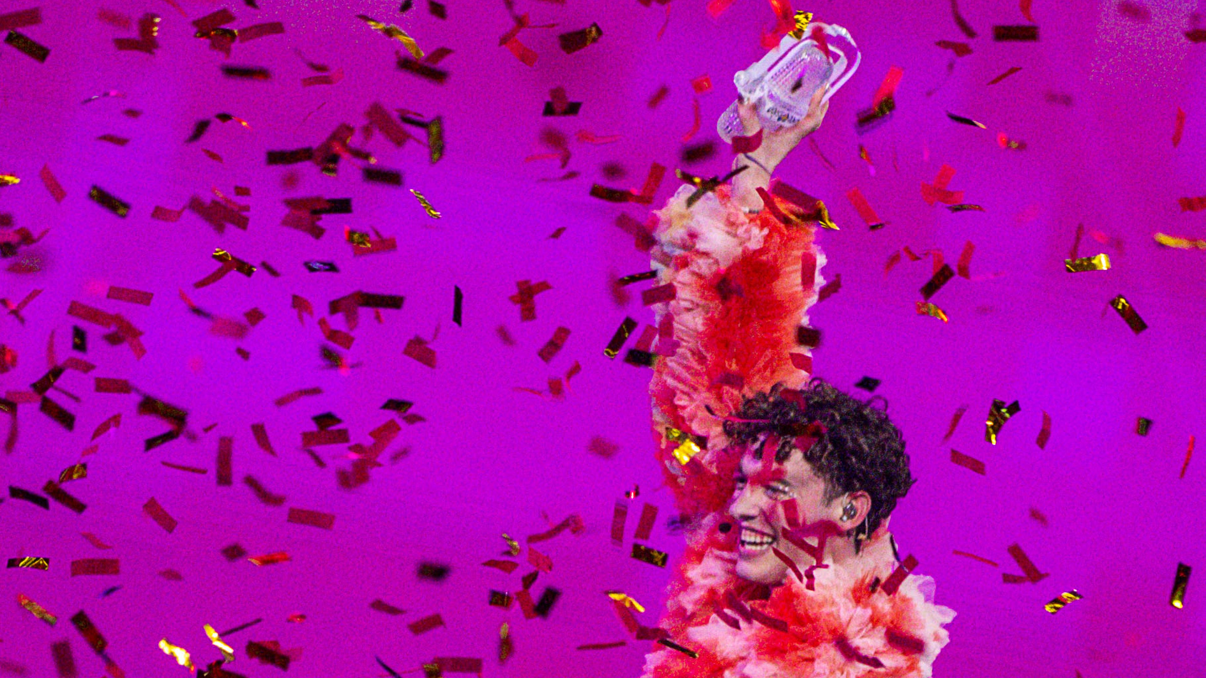Nemo aus der Schweiz streckt bei der Siegerehrung im Finale des Eurovision Song Contest (ESC) 2024 den kaputten Pokal in die Höhe. 