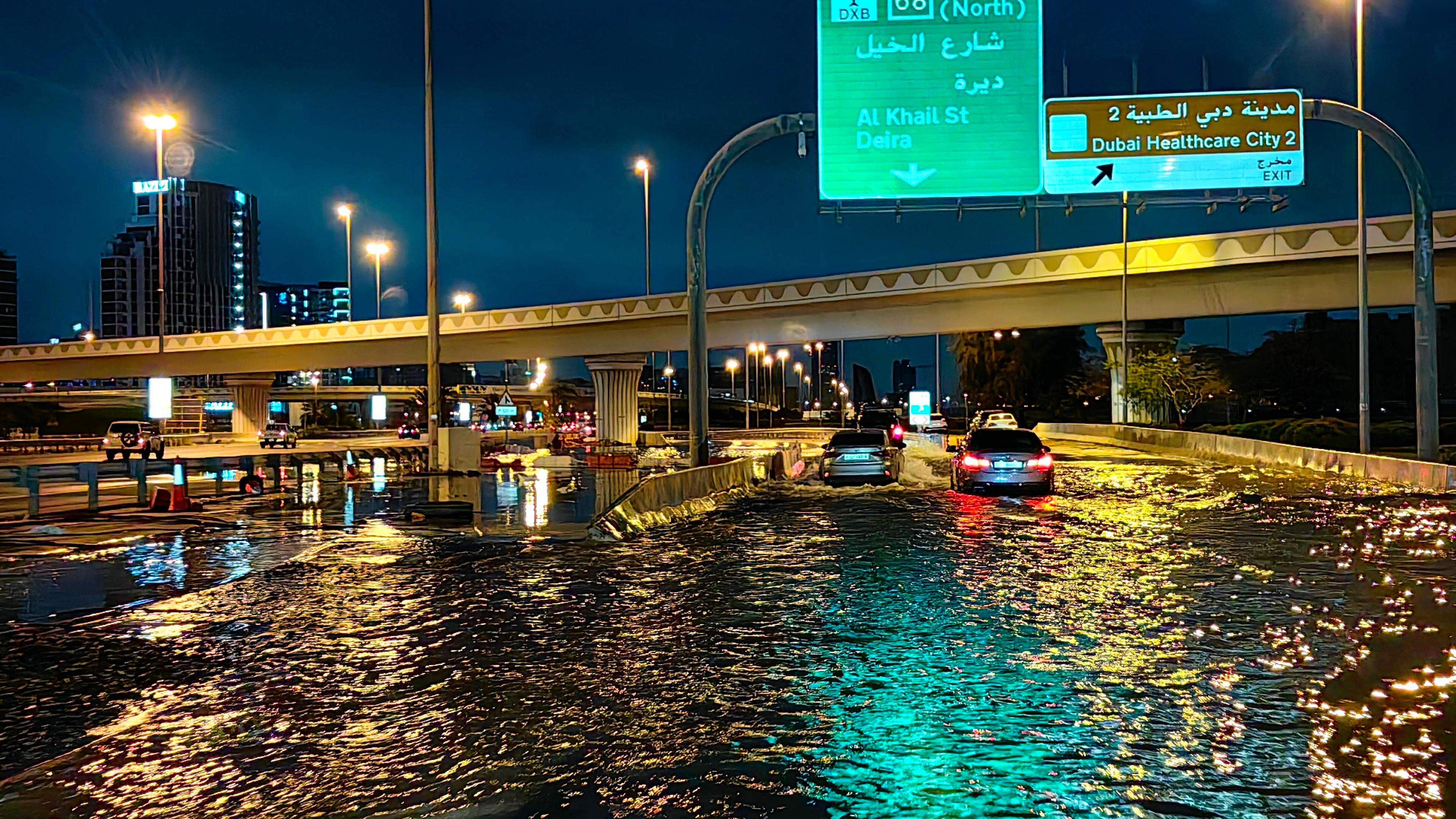 Motorisits drive along a flooded street following heavy rains in Dubai early on April 17, 2024. Dubai, the Middle East's financial centre, has been paralysed by the torrential rain that caused floods across the UAE and Bahrain and left 18 dead in Oman on April 14 and 15. (Photo by Giuseppe CACACE / AFP)