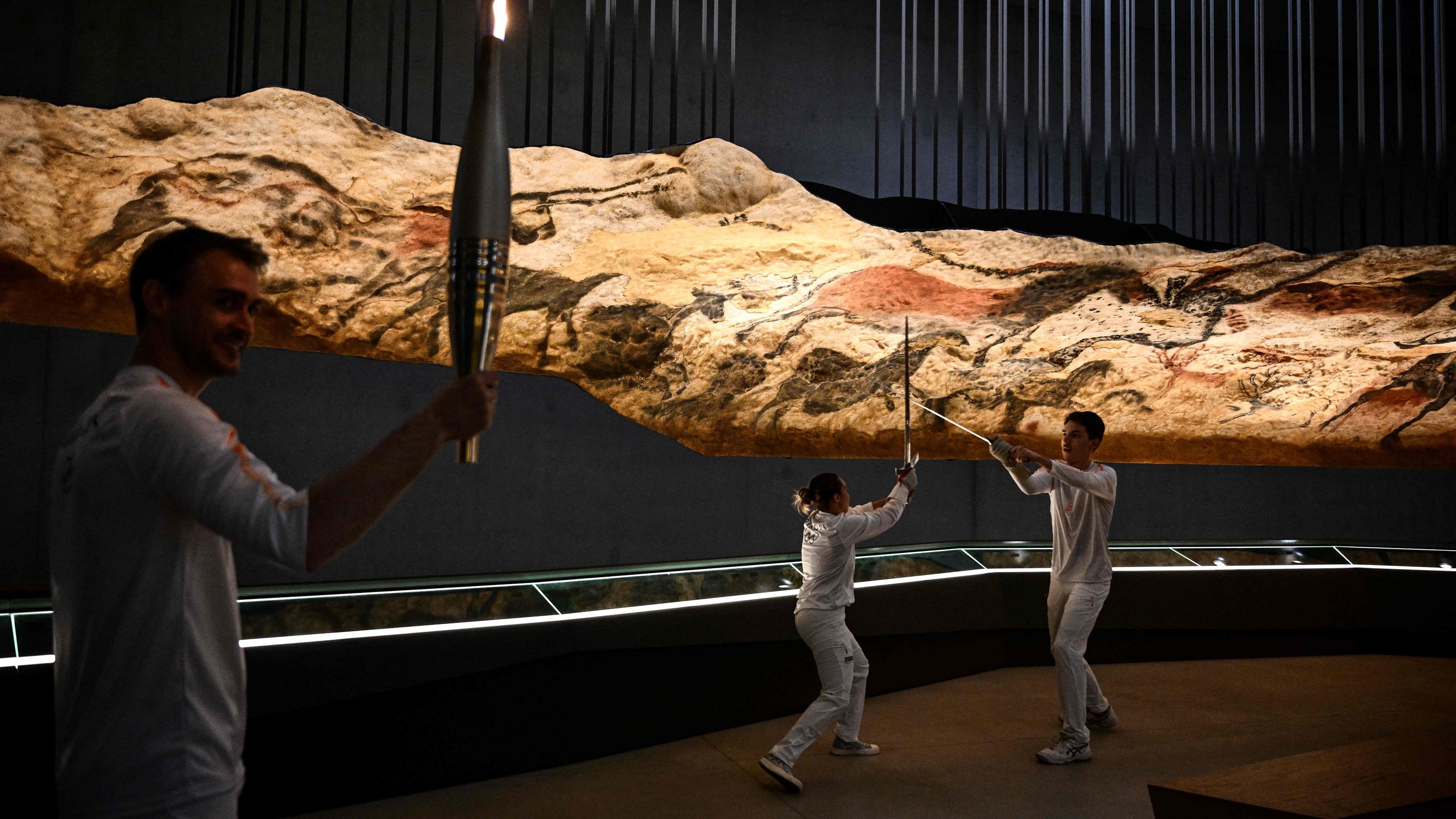 French fencing athletes carry the Olympflame on Wednesday in Montignac-Lascaux, France, ahead of the Paris 2024 Olympic Games. 