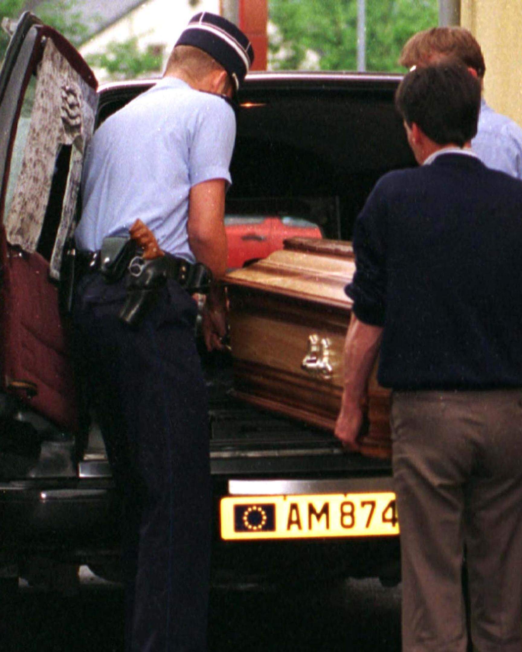 Luxemburger Gendarmen schieben den Sarg mit dem Leichnam von Günter Ewen in den Leichenwagen.