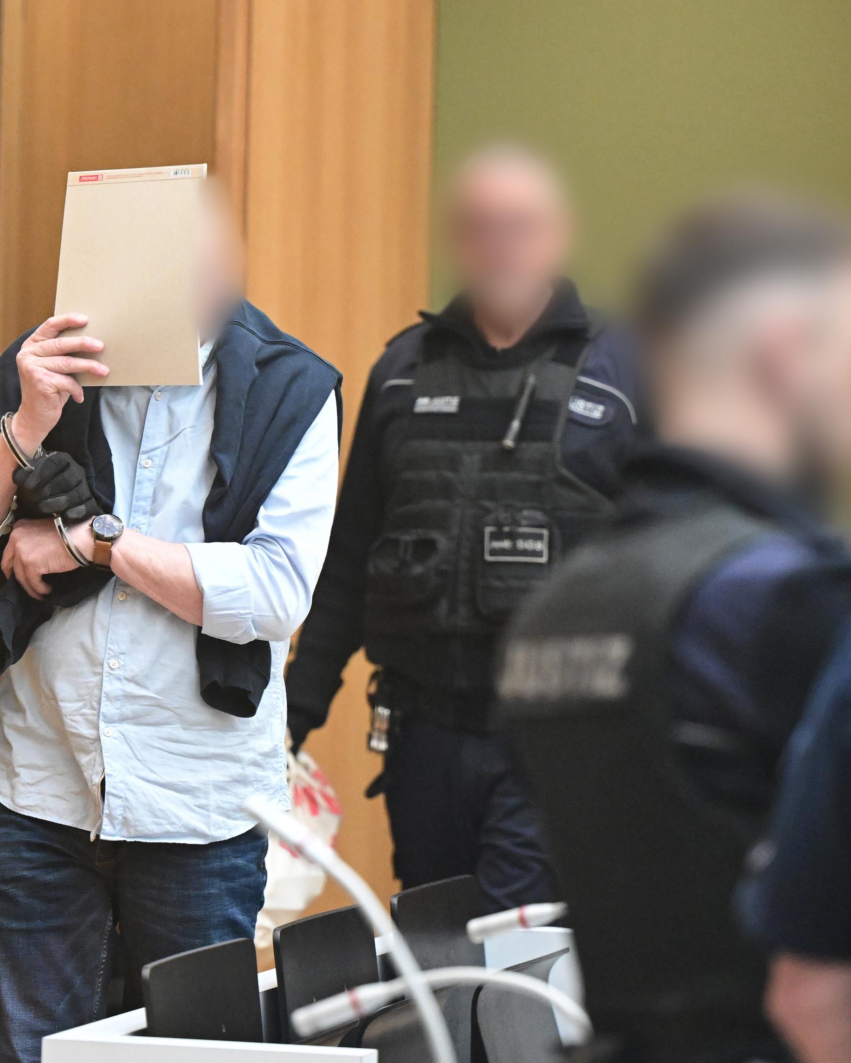Ein Angeklagter wird in Stuttgart-Stammheim beim Beginn eines Prozesses um Reichsbürger, die mutmaßlich einen Umsturz in Deutschland geplant haben sollen, in den Gerichtssaal geführt.