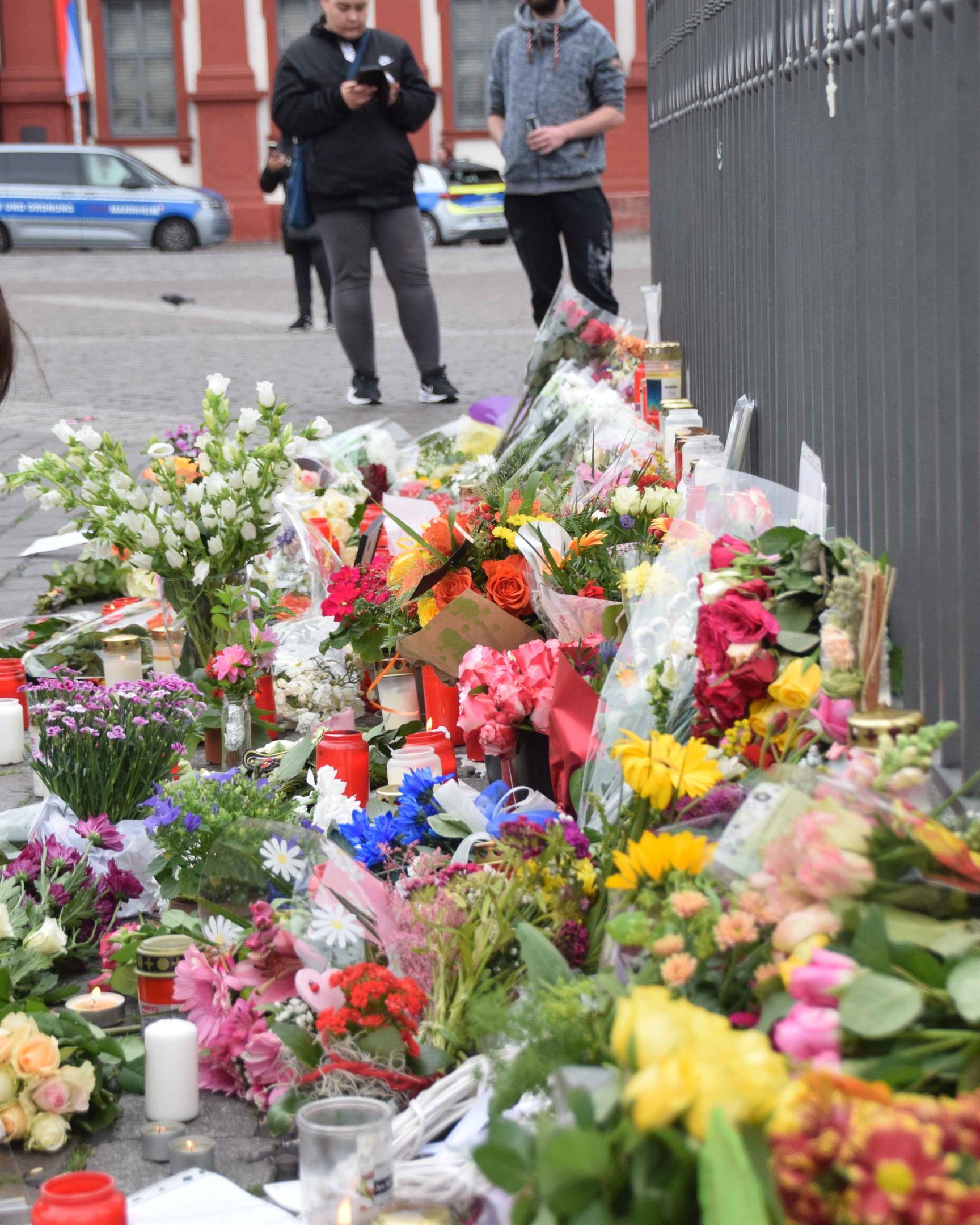 Blumen und Kerzen werden in unmittelbarer Nähe des Tatorts in Mannheim niedergelegt.