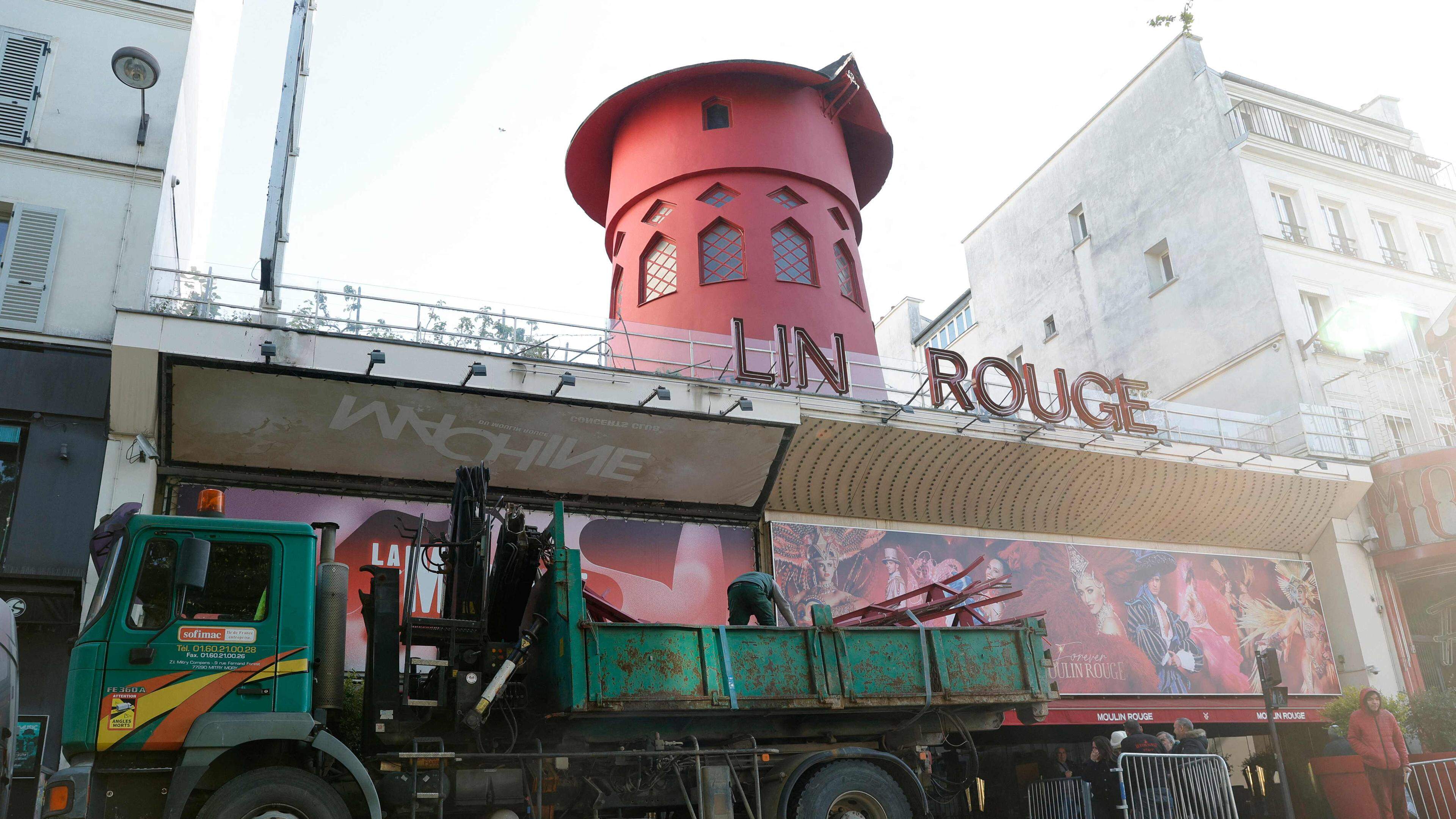 25.04.2024, Frankreich, Paris: Arbeiter sichern den Bereich vor dem Kabarett, nachdem die Flügel des Windrads des «Moulin Rouge» in der Nacht abgestürzt sind. Foto: Geoffroy Van Der Hasselt/AFP/dpa +++ dpa-Bildfunk +++