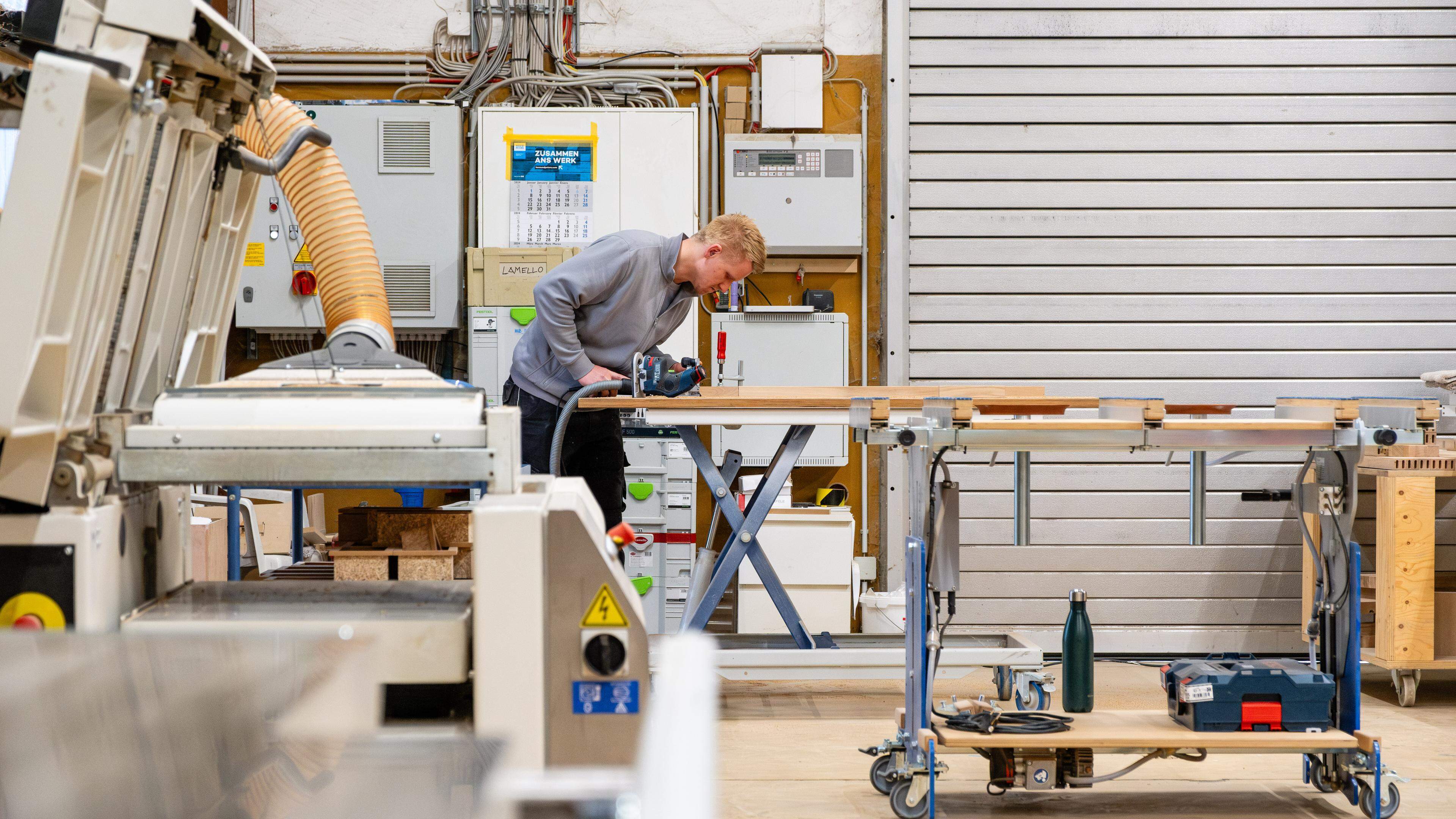 Mitarbeiter Lukas bei der Arbeit mit der Fräse, Mabian Holzmanufaktur: Möbelherstellung nach Maß, Mai 2024, Foto: Laurent Sturm